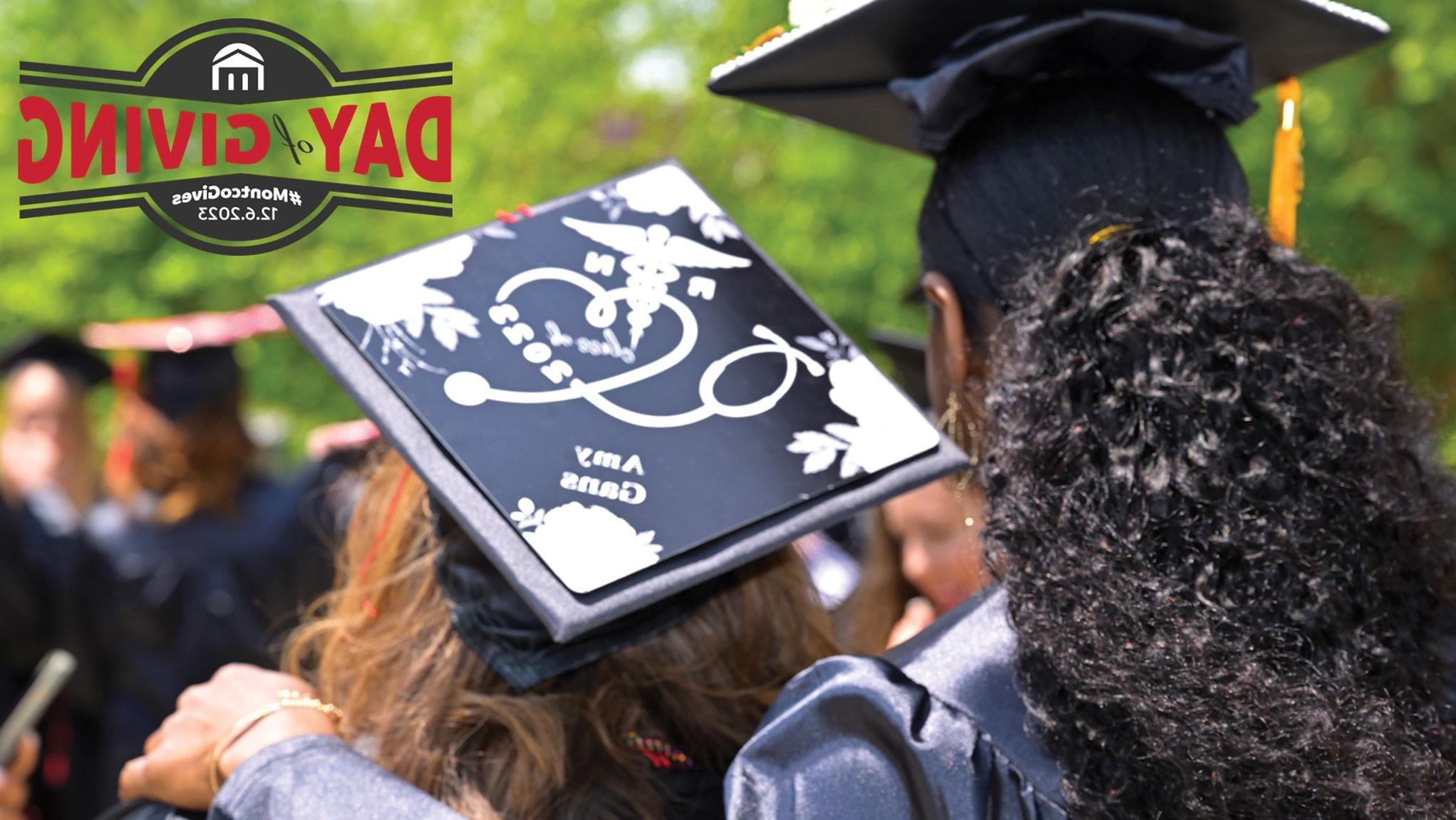 Backs of two graduates with Day of Giving logo